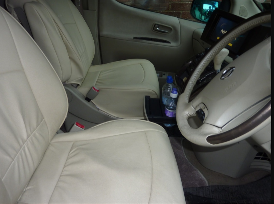 vanilla colored leather car seats with 2 bottled waters